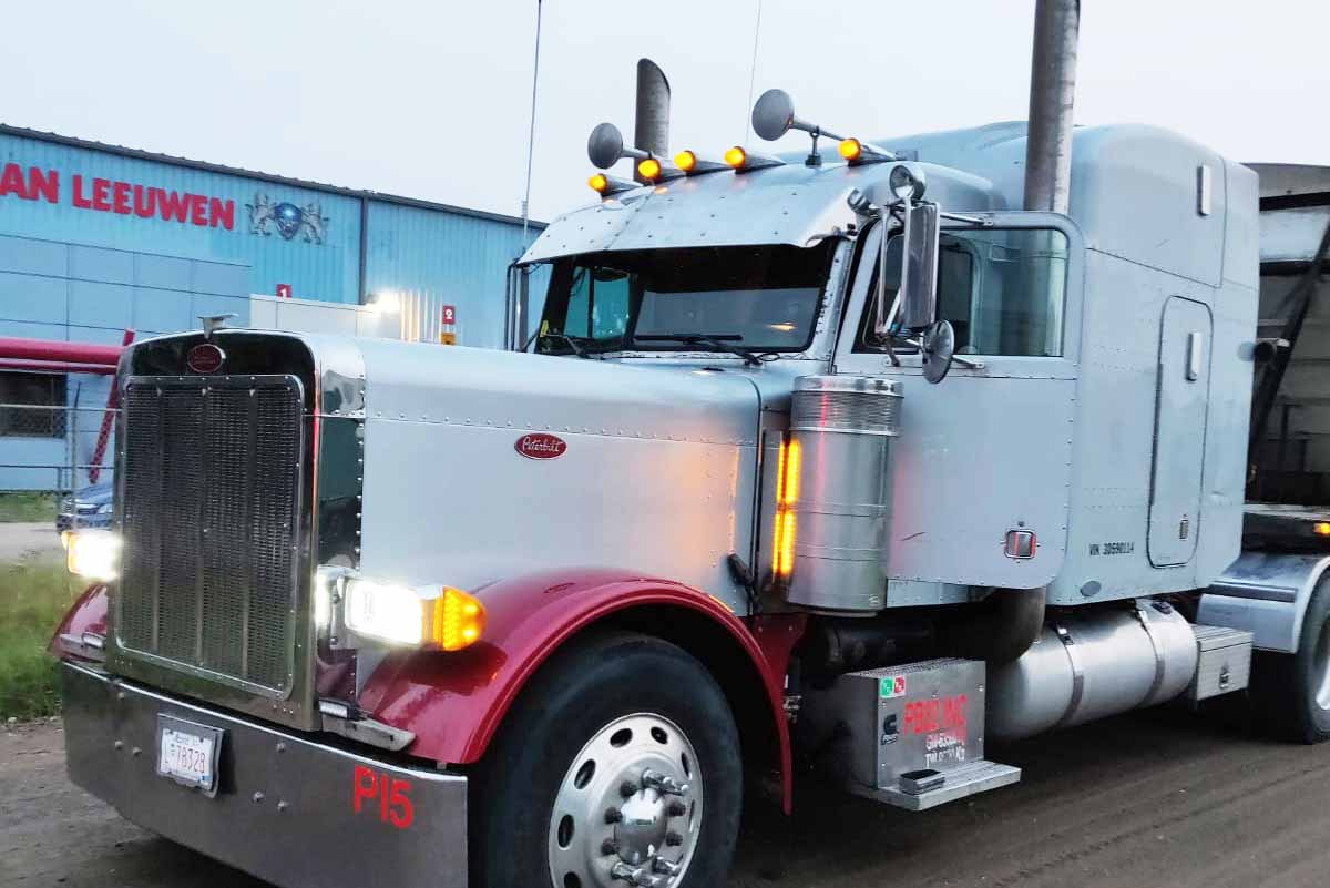 Peterbilt with red trim outside a warehouse
